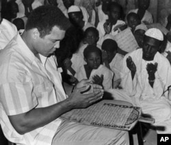 FILE - Muhammad Ali prays with a class of Muslim boys at Dafaalah el Sa'em Mosque in Khartoum, Sudan, Nov. 23, 1988.