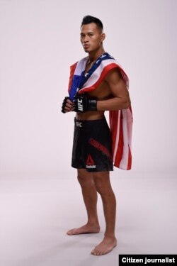 ທ້າວ ອອນເດຣ ພ້ອມກັບທຸງຊາດລາວ ແລະ ສະຫະລັດ.