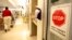 FILE- A sign urging staff and patients to wash their hands hangs on the wall as a patient is wheeled through the emergency room at Greater Baltimore Medical Center in Towson, Maryland, Nov. 3, 2009.