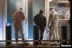 مأموران پلیس پس از گزارش صدای انفجار مهیب در محل سفارت آمریکا در بامداد یکشنبه، این محل را بازرسی می‌کنند.