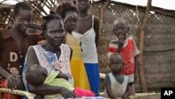 Yanut Ayuel, 2nd left, sits with her family at the displaced persons' camp where she lives in Abayok, South Sudan, Aug. 20, 2017.