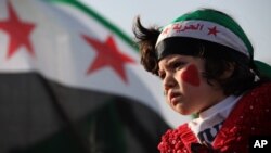 A girl wears a headband in the colors of the Syrian revolutionary flag and painted her face with hearts during a protest in front of the Syrian embassy in Amman, Jordan, May 17, 2013.