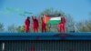 Orang-orang membentangkan bendera Palestina di Pabrik Elbit, di Leicester, Inggris, 19 Mei 2021. (Foto: Guy Smallman/Palestine Action via Reuters)