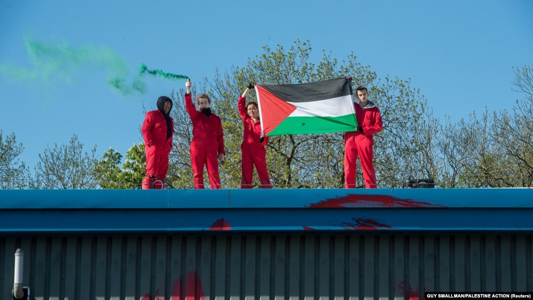 Orang-orang membentangkan bendera Palestina di Pabrik Elbit, di Leicester, Inggris, 19 Mei 2021. (Foto: Guy Smallman/Palestine Action via Reuters)