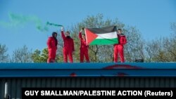 Orang-orang membentangkan bendera Palestina di Pabrik Elbit, di Leicester, Inggris, 19 Mei 2021. (Foto: Guy Smallman/Palestine Action via Reuters)