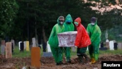 Para petugas pemakaman mengusung peti jenazah korban virus corona (COVID-19) untuk dimakamkan, Jakarta, 31 Maret 2020. (Foto: Reuters)