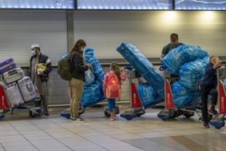 Güney Afrika'nın Johannesburg kentindeki havaalanında ülkeden ayrılmak için kuyrukta bekleyen yolcular