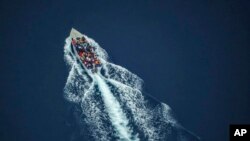 Des migrants naviguent sur une embarcation en bois dans la mer Méditerranée entre l'Afrique du Nord et l'île italienne de Lampedusa, le 2 octobre 2021.