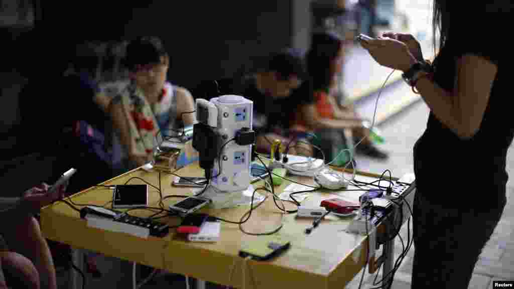 Protesters charge their mobile phones outside of an art centre near the government headquarters building in Hong Kong, Oct. 1, 2014. 