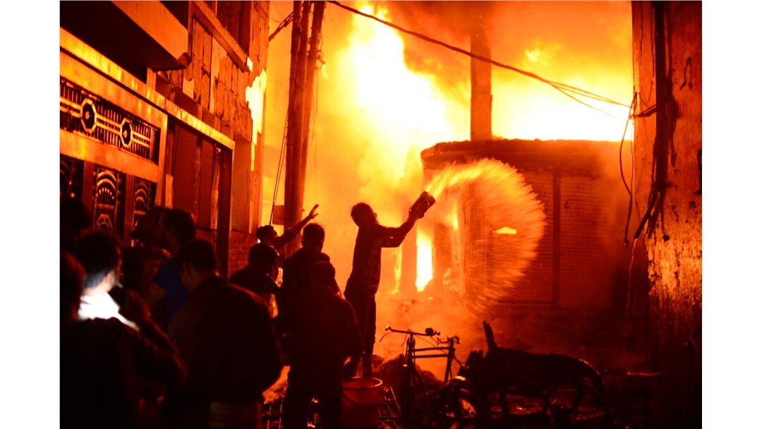 Para petugas pemadam kebakaran dan warga berusaha memadamkan api di sebuah pabrik garmen yang terbakar di Dhaka, Bangladesh, 20 Februari 2019.