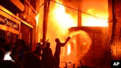 Para petugas pemadam kebakaran dan warga berusaha memadamkan api di sebuah pabrik garmen yang terbakar di Dhaka, Bangladesh, 20 Februari 2019.