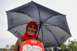 Seorang aktivis HAM dalam aksi di depan istana kepresidenan di Jakarta menuntut keadilan untuk korban kerushan Mei 1998, di Jakarta, 17 Mei 2018. (Foto: AFP)