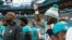 Miami Dolphins defensive end Robert Quinn raises his right fist during the singing of the National Anthem, before the start of an NFL preseason football game against the Tampa Bay Buccaneers, Aug. 9, 2018 in Miami Gardens, Fla.