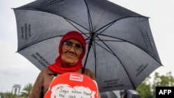 Seorang aktivis HAM dalam aksi di depan istana kepresidenan di Jakarta menuntut keadilan untuk korban kerushan Mei 1998, di Jakarta, 17 Mei 2018. (Foto: AFP)