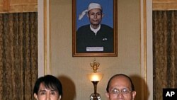 Burma's democracy icon Aung San Suu Kyi and President Thein Sein pose for photos before their meeting at the presidential office in Naypyidaw, August 19, 2011