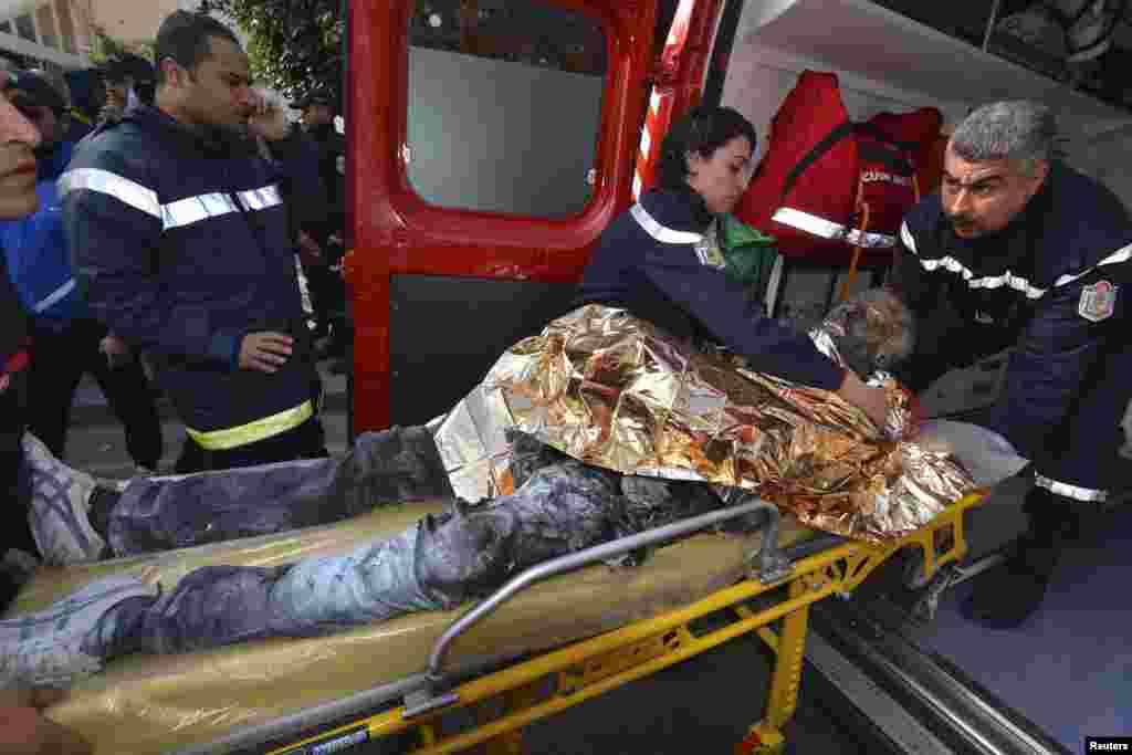 The body of a young Tunisian man, who set himself on fire, is transported into an ambulance in the main street of the capital Tunis. 