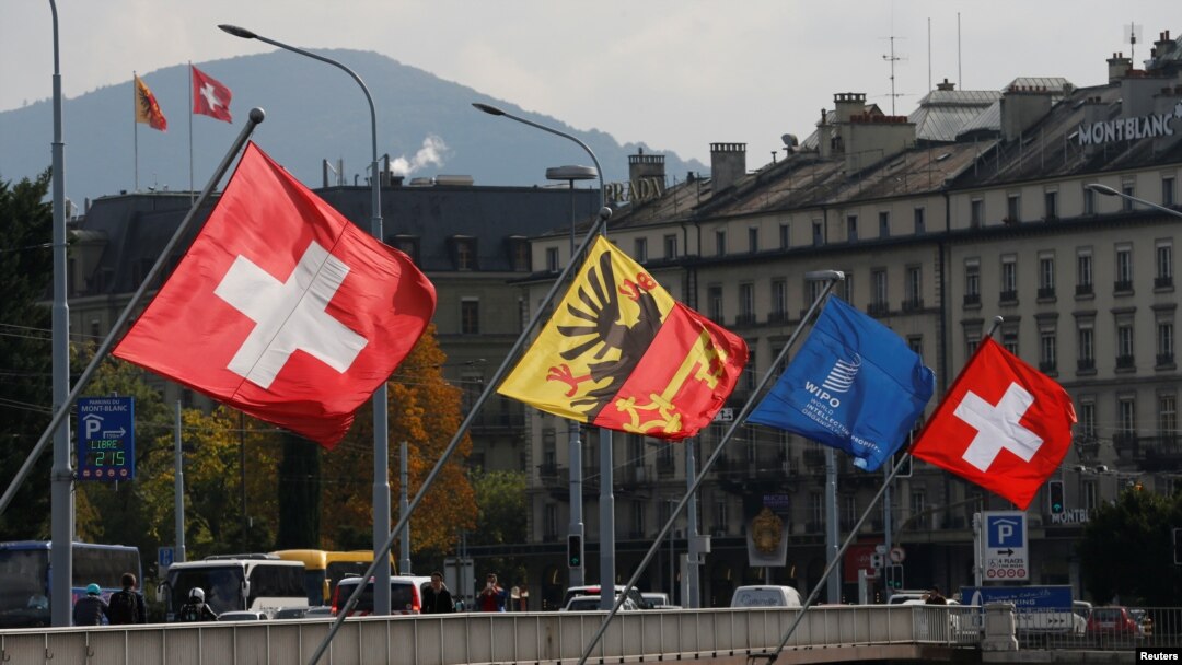 FILE - Swiss and Canton of Geneva flags are seen flying on the Mont-Blanc bridge in Geneva, Switzerland, Oct. 11, 2016. Swiss lawmakers plan to submit to government a new broad EU treaty that would replace patchwork of bilateral deals now under strain from immigration.