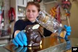 FILE—Niaz Mardan wraps a luxury handmade Belgian chocolate rabbit at Sandrine a chocolate shop in south west London, March 21, 2024.