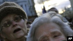 A Hungarian protestor covers her mouth with a mask during a protest in support of the largest opposition radio station 'Klub Radio', which recently lost its radio frequency in Budapest, Sunday, Jan. 22, 2012.