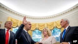 President Donald Trump watches as Vice President Mike Pence, right, administers the oath of office for Eugene Scalia, second from left, to be the next Labor Secretary during a ceremonial swearing-in ceremony at the White House, Sept. 30, 2019.
