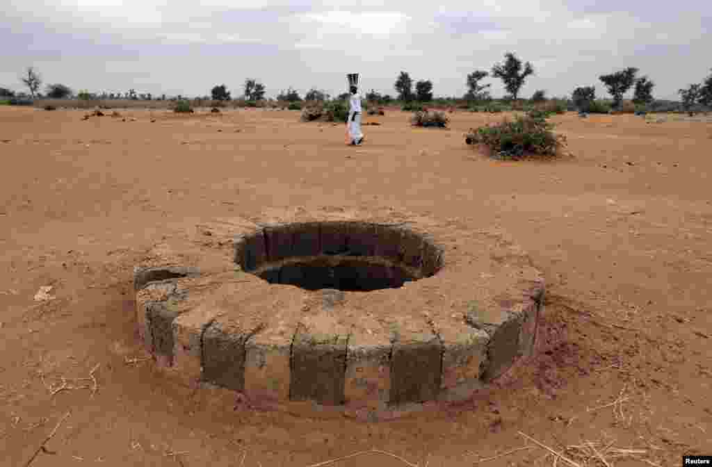 A woman walks past the well, where the bodies of suspected Islamist rebels, director of Human Rights Watch, Philippe Bolopion, had been dumped, according to U.N., in Sevare, Mali. Rights groups are worried ethnic reprisals will spread as parts of the north are retaken by Malian and French troops.