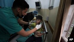 Seorang petugas medis merawat seorang anak laki-laki yang terluka setelah ledakan di kota Beit Lahiya, Jalur Gaza utara, pada hari Senin, 10 Mei 2021, selama konflik antara Hamas dan Israel. (Foto: AP / Mohammed Ali)