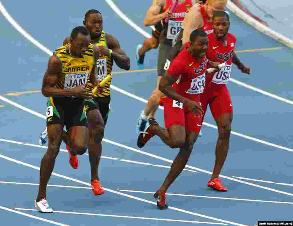 (L-R) Usain Bolt of Jamaica takes the baton from teammate Nickel Ashmeade, as Justin Gatlin of the U.S. takes the baton from teammate Rakieem Salaam in their men's 4x100 metres relay final during the IAAF World Athletics Championships at the Luzhniki stad