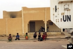 FILE - Children watch as a MINUSMA peacekeeping armored vehicle drives past in Kidal, Mali, July 23, 2015.