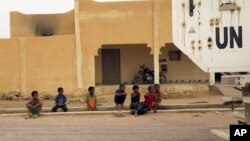 Des enfants contemplent un véhicule de la mission de l'ONU au Mali, la MINUSMA, dans une rue de Kidal, le 23 juillet 2015. 