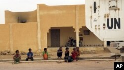 FILE - Children watch as a MINUSMA peacekeeping armored vehicle drives past in Kidal, Mali, July 23, 2015. 