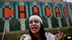 FILE - Carolina Moreno talks to journalists while performing as "Lady Justice" during a protest against Venezuela's President Nicolas Maduro in Caracas, Venezuela, Oct. 26, 2016. 