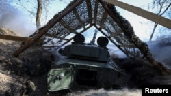 FILE - Artillerymen of the 15th Operative Purpose Brigade 'Kara-Dag' of the National Guard of Ukraine fire a 2S1 Gvozdika self-propelled howitzer toward Russian troops in a front line, near the town of Pokrovsk in Donetsk region, Ukraine October 3, 2024. 