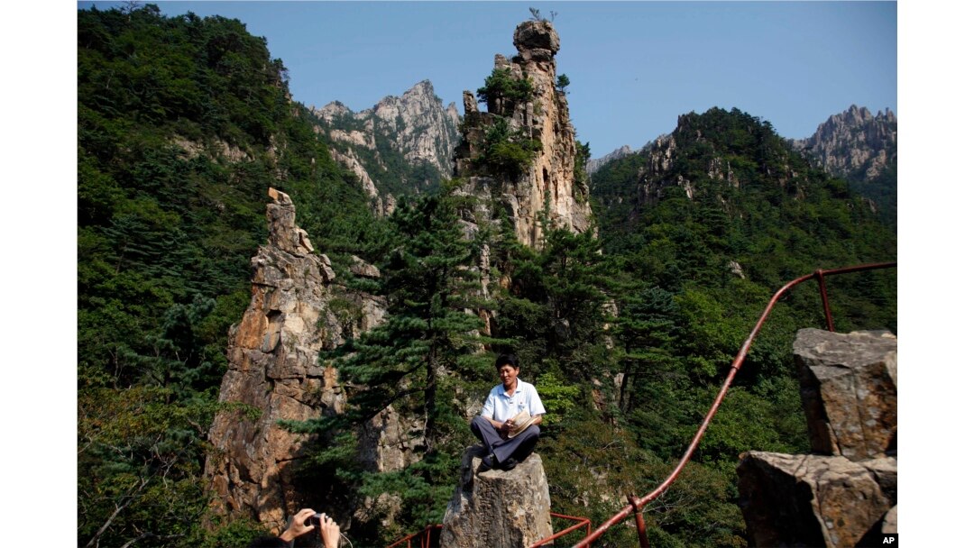 Pemandu Korea Utara berpose di antara puncak resor Gunung Kumgang, juga dikenal sebagai Gunung Berlian, di Korea Utara, 1 September 2011. (Foto: AP)