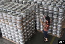 FILE - An employee checks pots that will be exported to South Africa at a factory in Hangzhou in China’s eastern Zhejiang province, June 25, 2018.
