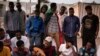 A protester plays music at the sit-in outside the military headquarters in Khartoum, Sudan, Saturday, April 20, 2019. 