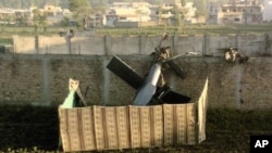 This photo, taken by a local resident, shows the wreckage of a helicopter next to the wall of the compound where according to officials, Osama bin Laden was shot and killed in a firefight with U.S. forces in Abbottabad, Pakistan, May 2, 2011 (file photo)