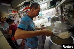 Hawker Lim Swee Heng prepares a bowl of laksa noodles, at Roxy Laksa stall, at the East Coast Lagoon Food Village in Singapore, Aug. 8, 2016.