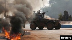 French troops secure an area after protesters from an angry mob set fire to the dead body of a Muslim man along a street in Bangui, Central African Republic, Jan. 19, 2014. 