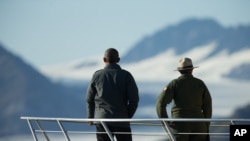 President Barack Obama, accompanied by a National Park Service employee looks at Bear Glacier, which has receded 1.8 miles in approximately 100 years, while on a boat tour to see the effects of global warming in Resurrection Cove, Sept. 1, 2015, in Seward