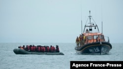 Migrants are helped by RNLI (Royal National Lifeboat Institution) lifeboat before being taken to a beach in Dungeness, on the south-east coast of England, Nov. 24, 2021, after crossing the English Channel.