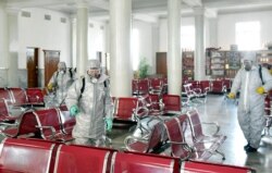This undated picture released from North Korea's official Korean Central News Agency (KCNA) on February 15, 2020 shows people in protective suits spraying disinfectant at an undisclosed location in North Korea, amid concerns of the COVID-19.