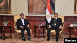 Presiden Mesir Mohamed Morsi (kanan), dan Presiden Iran Mahmoud Ahmadinejad setibanya di bandara Internasional di Kairo (5/2).