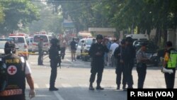 Police officers stand guard in front of a Catholic Church in Ngagel, Surabaya.