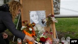 Seorang perempuan menyalakan lilin dalam doa bersama untuk turis Inggris Grace Millane di Cathedral Square di Christchurch, Selandia Baru, 12 Desember 2018. (Foto: AFP)