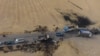 An areal picture taken on Oct. 28, 2019, shows vehicles near a destroyed truck at the spot where Abu Hassan al-Muhajir, the Islamic State (IS) group's spokesman, was reportedly killed in a raid in the Syrian village of Ayn al-Bayda near Jarablus.
