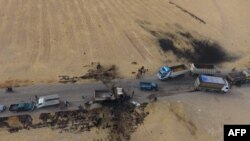 Foto udara yang diambil pada 28 Oktober 2019, memperlihatkan kendaraan di dekat truk yang hancur di lokasi Abu Hassan al-Muhajir, jubir kelompok ISIS, dilaporkan tewas dalam serangan di desa Ayn al-Suriah di Suriah. 