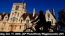 A cyclist is silhouetted in front of Balliol College, founded in 1263. It is one of the oldest colleges of Oxford University in Oxford, England, Friday, Oct. 17, 2008. (AP Photo/Kirsty Wigglesworth)