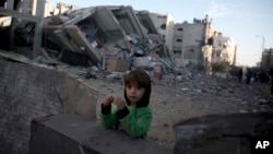 13일 팔레스타인 가자 시티에서 어린 소년이 이스라엘 공습으로 파괴된 하마스의 '알 아크사' TV 방송국 주위에서 놀고 있다. 