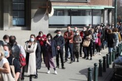 FILE - People queue outside a COVID-19 vaccination center in Brussels, Belgium, March 3, 2021.