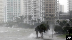 ARCHIVO - Esta foto de archivo del 10 de septiembre de 2017 muestra olas rompiendo sobre un muro de contención en la desembocadura del río Miami desde la bahía de Biscayne, Florida, mientras el oleaje de la tormenta del huracán Irma afecta a Miami.